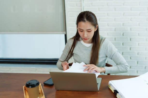istock business owner, beautiful Asian woman. Working, checking various sales investment notebooks documents. croissants and paper coffee cups. prepare torder bakery ingredients small family business cafe. 2005559607