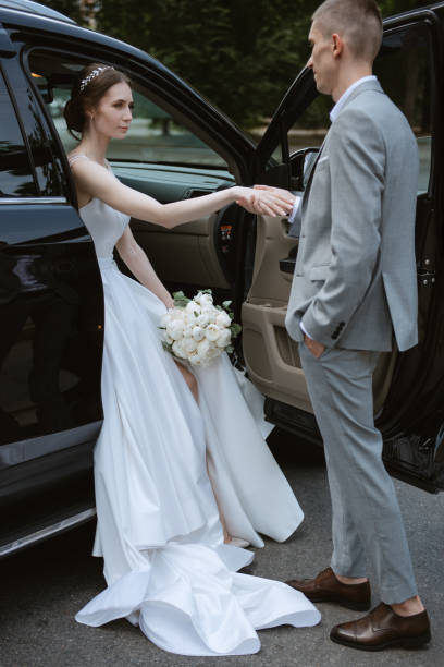 istock bride and groom with a black car 2005570754