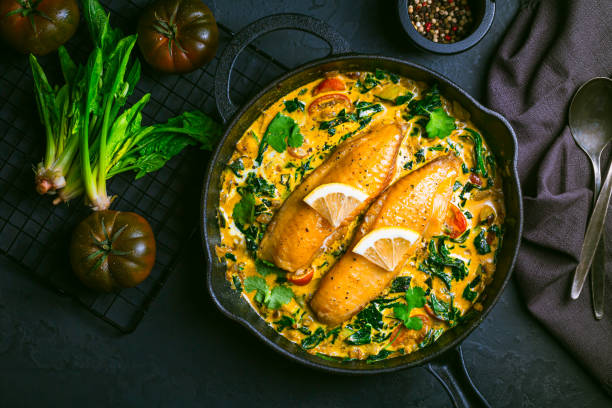 istock Red curry with spinach, coconut milk and baked fish in a pan 2005582709