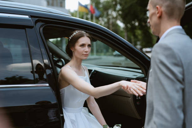 istock bride and groom with a black car 2005604364