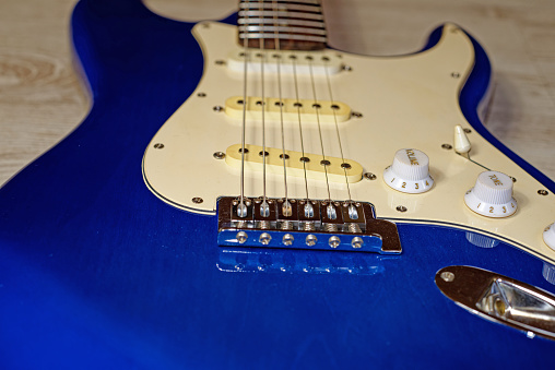 Music, pop, rock: blue electric guitar, close-up of bridge, strings and controls