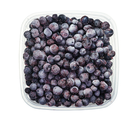 Plastic container with frozen blueberry. Top view of frozen food isolated on white background. Storage for winter storage in trays