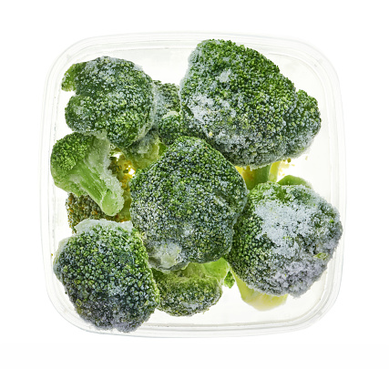 Broccoli floret in plastic container. Top view of frozen vegetables isolated on white background. Storage for winter storage in trays