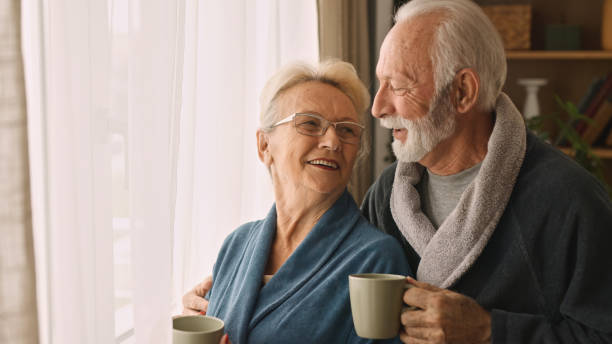 Happy senior couple drinking coffee or tea indoors