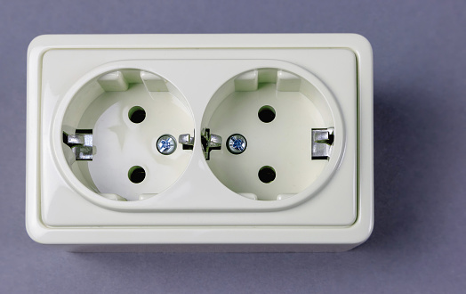 Double socket with earthing on a gray background top view