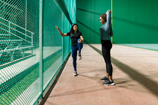 Two young women stay active after hours, adhering to their nighttime fitness regimen with dedication and resolve.