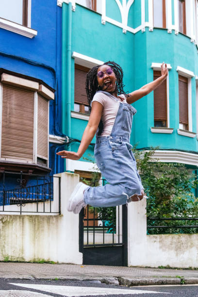 istock Exuberant Young Lady Jumping for Joy in the City 2005717794