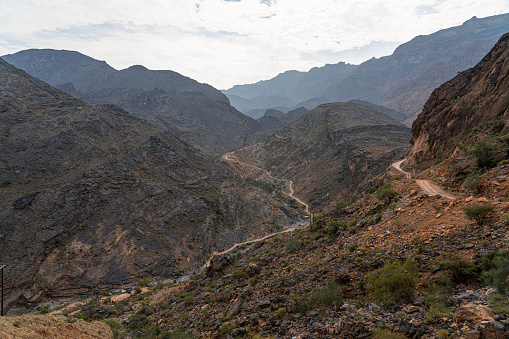 Spectacular dirt road through Wadi Bani Awf in Hajar mountains —one of Oman’s most picturesque valley.