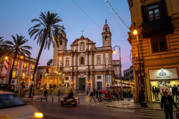 San Domenico is a Baroque-style Roman Catholic church, located on Piazza San Domenico, and located in the ancient quarter of La Loggia, in central Palermo, region of Sicily, Italy Palermo, Italy - December 24, 2022: A vibrant and bustling town square in san Domenico, Palermo, Italy, adorned with towering palm trees and a magnificent cathedral, all basking in the warm glow of a stunning blue hour. Nestled within the ancient quarter of La Loggia, this architectural masterpiece is a testament to Sicily's rich cultural heritage. piazza san domenico stock pictures, royalty-free photos & images