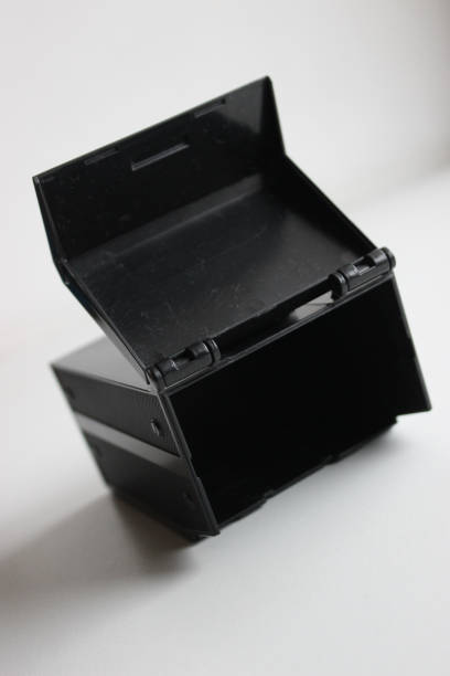 istock Opened Lid Of Black Plastic Container Lying On Clean White Surface 2005741440