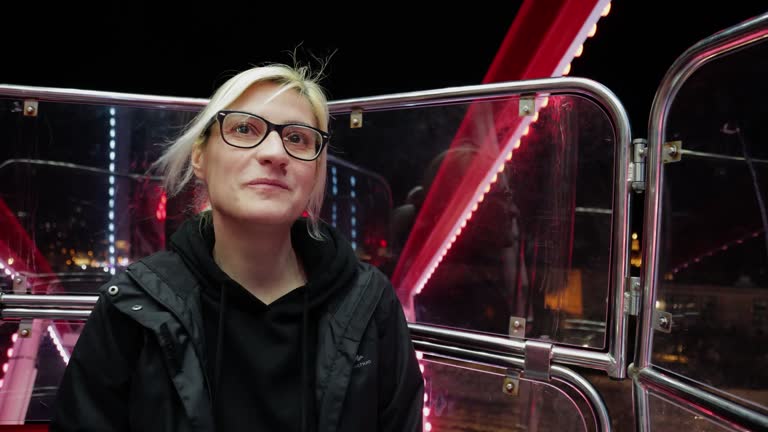 everyone loves a merry-go-round, no matter how old they are-mature woman in Amusement park