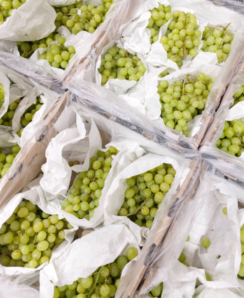istock Grapes in white bags at store. 2005810083