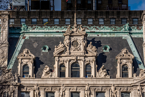 This view features the abundant architectural detail of the mansard roof of the Surrogate’s Court in Lower Manhattan. \n\nLocated at 31 Chambers Street, the Surrogate’s Court is a distinguished legal landmark serving as the center for probate matters in New York County. Completed in 1907 and designed by architect John R. Thomas, this Beaux-Arts-style courthouse exudes grandeur with its imposing facade, featuring classical details and an interior central dome.