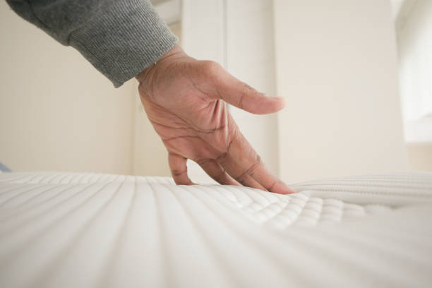 istock Hand touching and pressing orthopedic mattress on bed. 2005815135