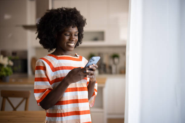 istock A young beautiful woman using a smart phone at home 2005823597