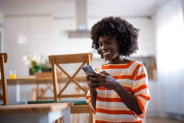 istock A young beautiful woman using a smart phone at home 2005825165
