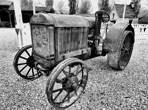 Sandwich, Massachusetts, USA- October 28, 2023-  A mature bearded man plows a agricultural field at Gopal Farm using an antique grey and red Ford tractor on a late October morning on Cape Cod.