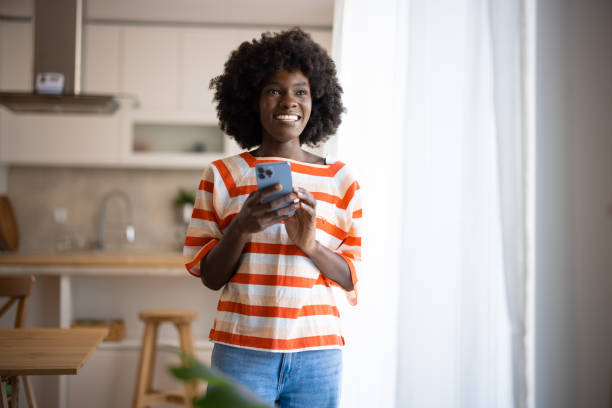 istock A young beautiful woman using a smart phone at home 2005826208