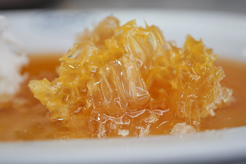 close up of fresh honey with comp in a jar .