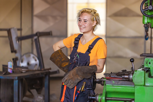 Portrait of female manual worker working in workshop .