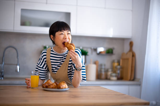 istock Japanese woman eating in the kitchen 2005839871