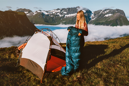 Woman hiker with tent camping gear morning in mountains active travel vacations outdoor, traveler girl hiking in Norway active adventure eco tourism healthy lifestyle hobby