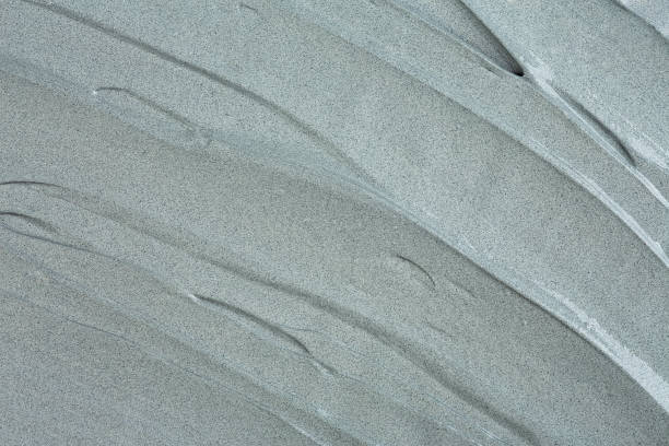 Grey cosmetic clay texture, top view. Abstract background with brush strokes. Mud mask for face and body.