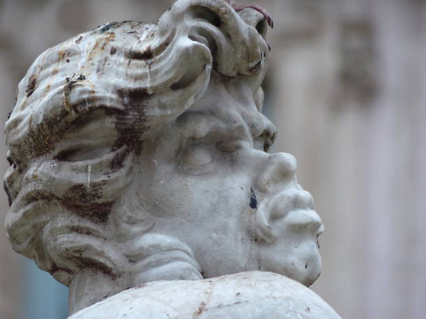 Ancient sculpture of a god or man wearing a helmet, viewed from below