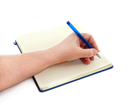Hand with pen and notebook isolated on a white background.