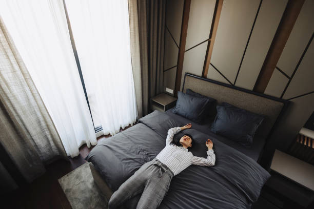 istock Tired woman lying on bed in hotel 2005874901