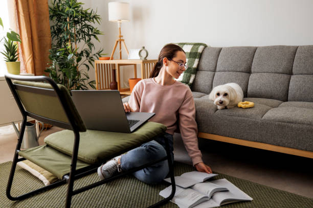 istock Young girl studying with her dog next to her 2005885650