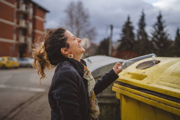 istock one woman stand with plastic garbage in front of recycle containers 2005890945