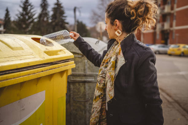istock one woman stand with plastic garbage in front of recycle containers 2005890946