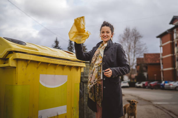 istock one woman stand with plastic garbage in front of recycle containers 2005894657