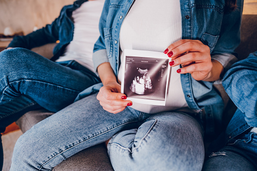 Pregnant woman shows ultrasound