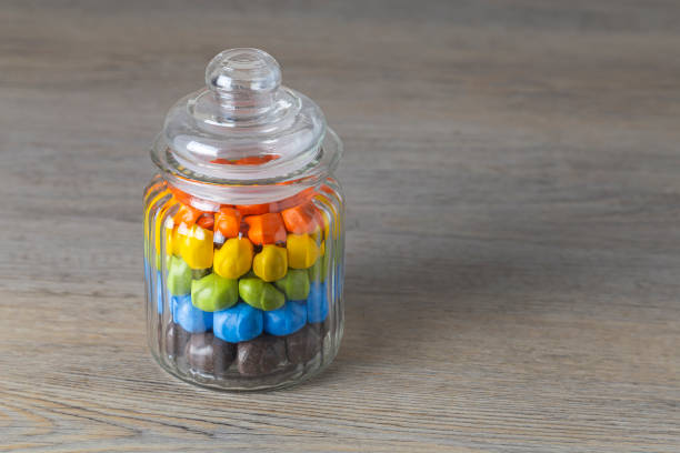 Milk chocolate Peanuts in a glass jar on a wooden table