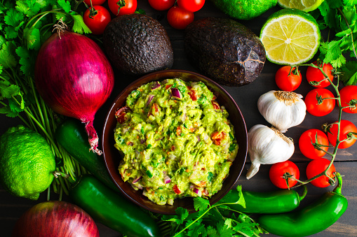 Guacamole with Hass avocados, jalapeno peppers, cherry tomatoes, and other ingredients
