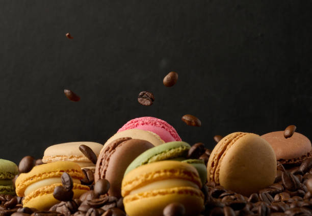 istock Stack of multi-colored macarons on a background of coffee beans, black background 2006002878