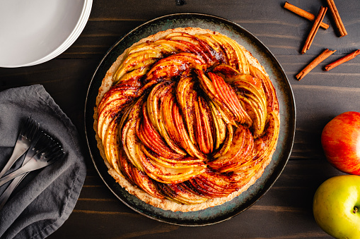 A tart made with cinnamon, sliced Ambrosia, Golden Delicious, and Granny Smith apples