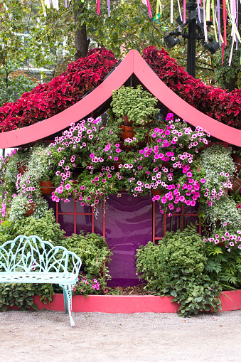 a flower house in the park with a bench. Landscaping decorated park in the city