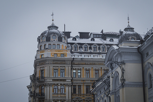 Kyiv, Ukraine - February 10, 2024, gloomy and gray weather. a little snow is falling. the city is hidden by white snow. people are walking outside. the architecture of the city is covered with snow