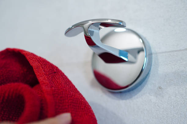 Woman hanging bath towel on towel rack in bathroom
