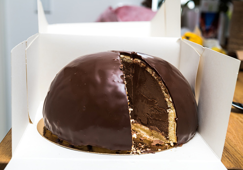 Cut slice of Delicious Bombe au chocolat translated chocolate bomb on the wooden table - anniversary holiday gift