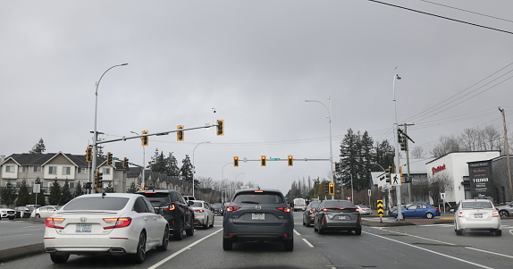 Surrey, Canada - February 3, 2024: Looking northwest on the Fraser Highway at 64th Avenue near townhouses and Clayton Market. Overcast winter morning in the East Clayton neighbourhood of Surrey.