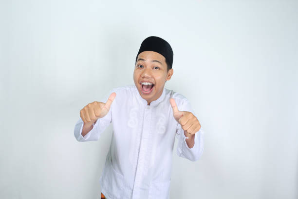 istock cheerful muslim asian man shouting while giving thumb up isolated on white background 2006199126