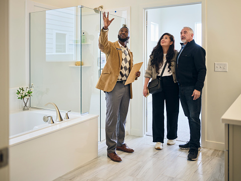 A professional real estate agent, showing a new home to prospective buyers.