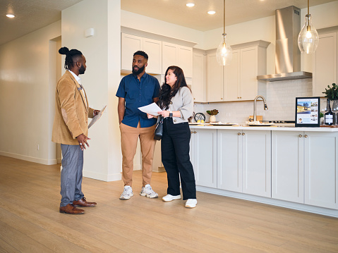 A professional real estate agent, showing a new home to prospective buyers.