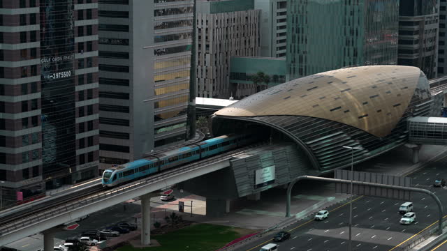 Establishing Shot of Dubai, UAE, Train Leaving Dubai Metro Station on Sheikh Zayed Road During Rush Hour