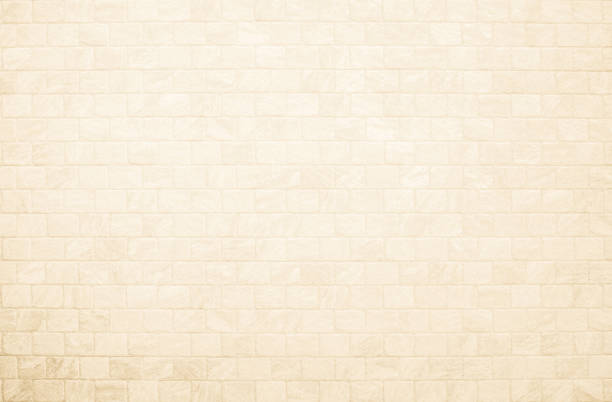 istock Empty background of wide cream brick wall texture. Beige old brown brick wall concrete or stone textured, wallpaper limestone abstract flooring. Grid uneven interior rock. Home decor design backdrop. 2006311554
