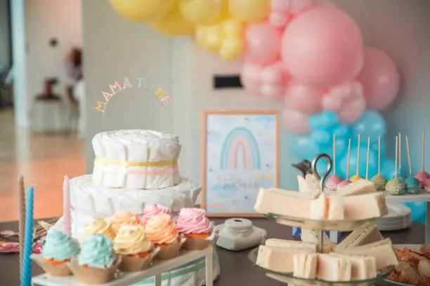 Photo of Pastel-Themed Baby Shower Decor with Diaper Cake Centerpiece